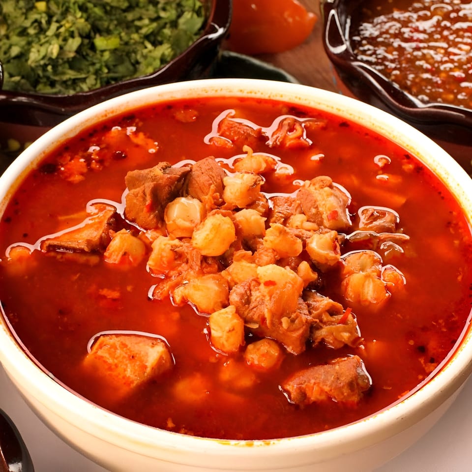 A bowl of Taqueria Los Portales' pozole, a rich red Mexican soup with hominy and pork.